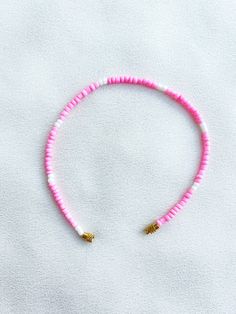 Handcrafted pink and white beaded anklet/bracelet. Made using small colourful round glass beads and finished with a gold-plated barrel clasp closure. Pair it with our matching Necklace.  * Weight: 3g   * Width: 5mm/2mm  * Made in UK  * Code: 111APWS The very best in unique, handmade pieces from BAM-BAM, our anklets and bracelets make great accessories for the beach, festival or club. These small beads have a dainty appearance and can take your best looks from day to night. Adjustable Pink Anklet With Colorful Beads, Pink Tiny Beads Anklets For Summer, Pink Anklets With Tiny Beads For Summer, Pink Heishi Beads For Beach, Summer Pink Beaded Bracelets With Heart Beads, Adjustable Pink Heishi Beads, Pink Heart Beads For Summer, Beaded Anklet, Glass Beads Jewelry