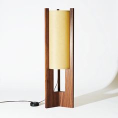 a wooden lamp with a yellow shade on it