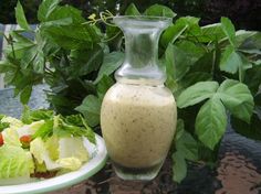 a glass vase sitting on top of a table next to a plate of salad