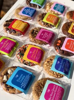 an assortment of cookies and pastries on display in plastic wrapper boxes with colorful labels