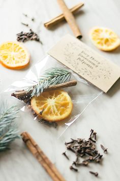 orange slices, cinnamon sticks and spices on a table with an envelope that says merry christmas