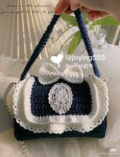 a crocheted purse with a bow on the handle