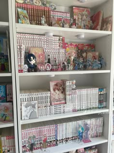 a book shelf filled with lots of books and anime figurines on top of it