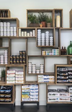 the shelves are filled with many different types of food and drink items in wooden boxes