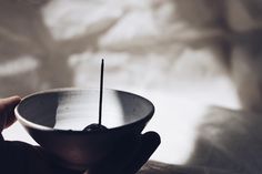 a person holding a bowl with a toothpick in it