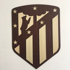 a wooden emblem with stars and stripes on the side of a white wall next to a black cat