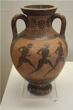 an old vase with two men running on it