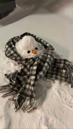 a snowman wearing a scarf and hat in the snow