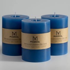 three blue candles sitting next to each other on a white surface with the label mozeal printed on them