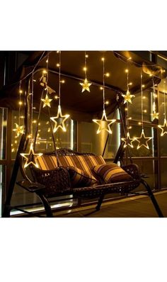 a swing chair with lights hanging from it's sides and stars on the ceiling