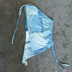 a blue jean hat laying on top of a gray carpet next to a pair of scissors