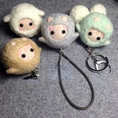 four stuffed animals are sitting on the floor next to a keychain with a leash