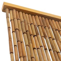 a close up view of the top of a bamboo wall hanging from a wooden frame