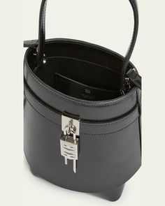 Givenchy "Shark Lock" bucket bag in leather     Features signature logo padlock accent     Flat top handle     Open top     Interior, one slip pocket     Approx. 7.4"H x 7.9"W x 5.7"D    Made in Italy Modern Evening Bucket Bag With Branded Hardware, Designer Formal Bucket Bag With Top Carry Handle, Formal Bucket Shoulder Bag With Top Handle, Formal Bucket-shape Shoulder Bag With Top Handle, Modern Formal Bucket Bag With Silver-tone Hardware, Designer Top Handle Bucket Bag With Metal Hardware, Designer Formal Bucket Bag With Palladium Hardware, Formal Bucket Bag With Top Handle And Branded Hardware, Formal Rectangular Bucket Bag With Palladium Hardware