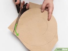 someone cutting out a piece of cardboard with scissors