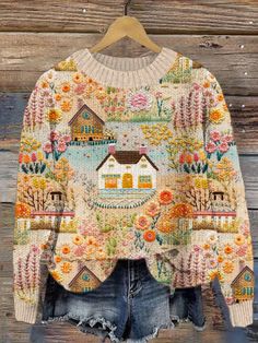 a sweater hanging on a wooden wall with an image of a house in the middle