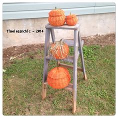 three pumpkins sitting on top of an old ladder