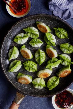 a pan filled with dumplings and sauce on top of a table