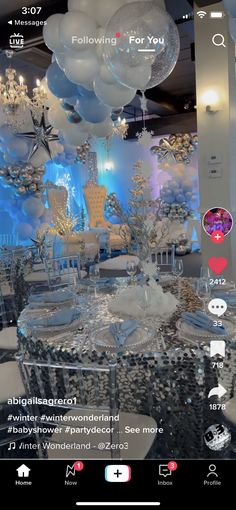 an image of a table set up for a party with balloons and snowflakes hanging from the ceiling