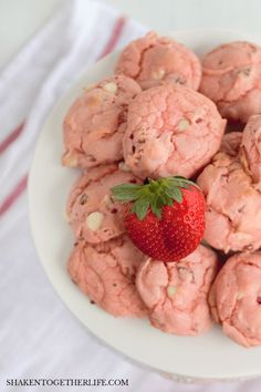 a white plate topped with cookies and a strawberry