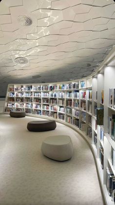 an empty library with many bookshelves and circular seating area on the floor,