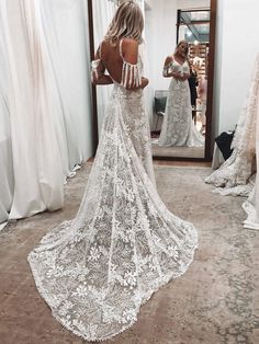 the back of a woman's wedding dress in front of a mirror with her reflection