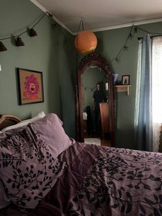 a bedroom with green walls and purple bedding