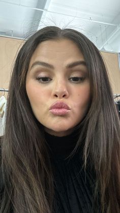 a woman with long brown hair is taking a selfie