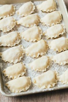 several uncooked ravioli on a baking sheet ready to be baked in the oven