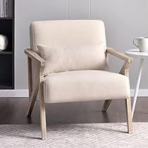 a white chair sitting in front of a book shelf next to a cup and saucer