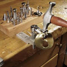 a man is working with metal tools on a wooden table