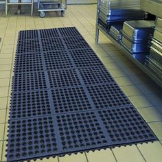 a floor mat is on the ground in a room filled with metal racks and bins