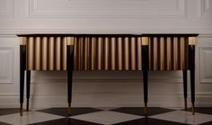 a black and white checkered floor with a gold console table