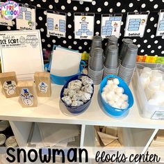 there are many items on the table for this snowman themed birthday party, including cookies and marshmallows