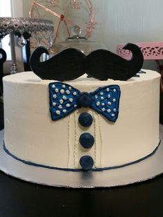 a cake with a mustache and bow tie on it