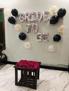 balloons and streamers decorate the entrance to a school graduation party with black and white confetti