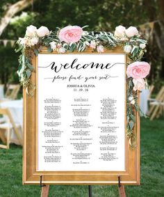 a wedding seating sign with flowers and greenery on the top is shown in front of a