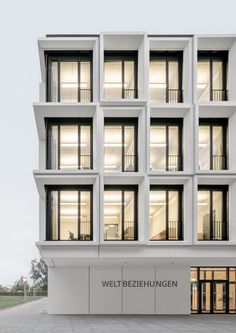 an apartment building with many windows and balconies on the top floor is lit up at night