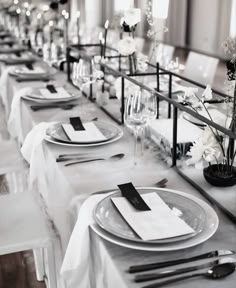 the table is set with white and black place settings