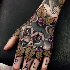 a person's hand with tattoos on it and an animal design on the palm