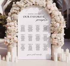 a wedding seating chart with flowers and candles in front of an arch that says our favorite people