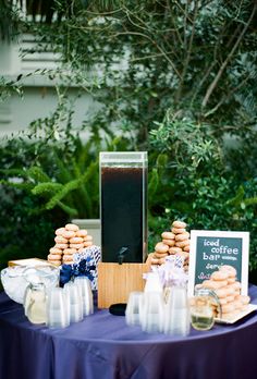 a table topped with cookies and wine glasses on top of a blue cloth covered table