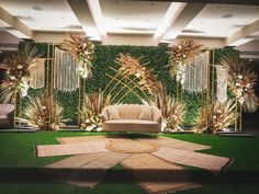 a living room decorated with greenery and couches in front of a green wall