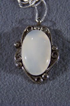 I am offering you this fabulous vintage sterling silver (stamped) extra large mother of pearl pendant charm and necklace chain. It features a gorgeous huge oval shaped setting , with spectacular large stone coverage. It has a bezel setting, to enhance this marvelous sterling silver setting the artist added lots curved lines.... Really giving this ring such allure and interest. It measures a very bold 1 3/4 inch by 1 inch The necklace chain is a very sturdy box link chain, that measures a very ve Silver Jewelry With Large Oval Cabochon Pendant, Silver Oval Cabochon Necklace For Anniversary, Vintage Oval Large Stone Necklaces, Vintage Oval Large Stone Necklace, Vintage Oval Necklace With Large Stone, Oval Large Stone Vintage Necklace, Silver Oval Victorian Necklace, Silver Victorian Oval Necklace, Victorian Silver Oval Necklace