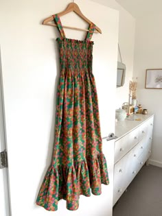 a dress hanging up on a wall next to a dresser