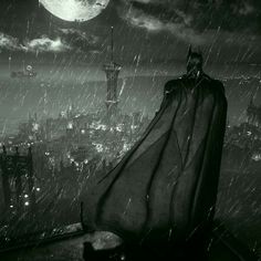 a batman standing on top of a building in the rain