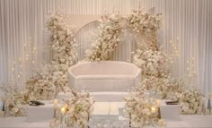 a white wedding ceremony setup with flowers and candles