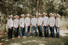 a group of men standing next to each other wearing cowboy hats