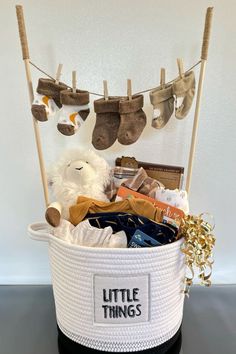 a white basket filled with baby items on top of a black table next to a wall