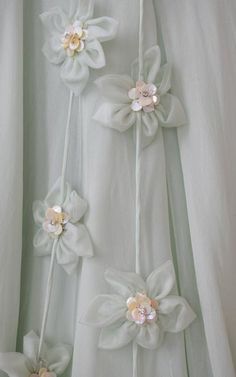 three white flowers are attached to the back of a dress